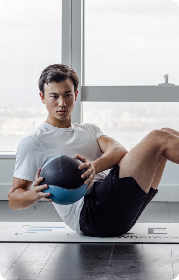 man performing a russian twist with a medicine ball